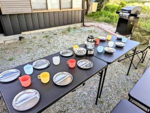 a picnic table with plates and cups and a grill at Lake Kawaguchiko, Vacation House, 3LDK BBQ OK !! 竹之家-Takenoya- Perfect for famiry and group travel !! in Fujikawaguchiko
