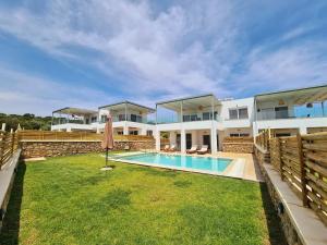 a large house with a swimming pool in the yard at Mythic Seaview Villas in Kiotari