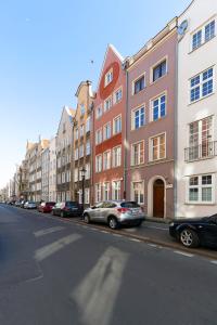 a row of buildings on a city street with parked cars at Old Town Premium by Elite Apartments in Gdańsk