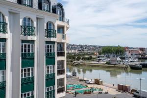 vista para um rio a partir de um edifício em SOWELL HOTELS Le Beach em Trouville-sur-Mer