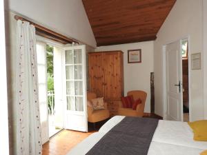 a bedroom with a bed and a chair and windows at Le Moulin De Saussaye in Crouzilles