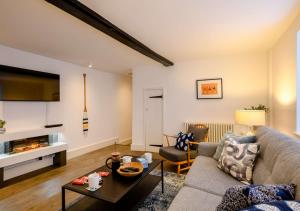 a living room with a couch and a table at 1 Carpenters Cottages in Holt