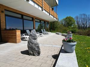 eine Terrasse mit Stühlen und einem Felsen vor einem Gebäude in der Unterkunft Ferienpark Geyersberg in Freyung