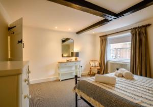 a bedroom with a bed and a desk and a window at 1 Carpenters Cottages in Holt