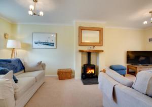 a living room with two couches and a fireplace at 1 Street Farm Cottages in Bodham