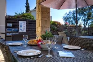 2 bedroom Villa Proteus with private pool, Aphrodite Hills Resort في كوكليا: طاولة مع كؤوس النبيذ وصحن من الطعام