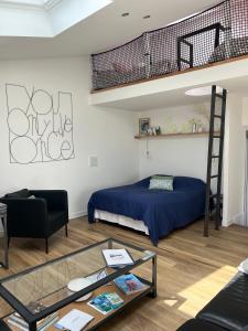 - une chambre avec un lit et une mezzanine dans l'établissement Appartement et Studio Gîtes de L'Odet, à Clohars-Fouesnant