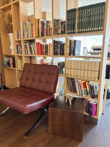 a chair in front of a book shelf with books at Good Morning Mölndal in Mölndal