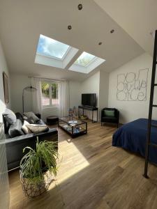 Appartement et Studio Gîtes de L'Odet في Clohars-Fouesnant: غرفة معيشة مع أريكة وسرير ونور
