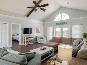 Una sala de estar con un sofá y un ventilador de techo. en Sunglow Bungalow, en Pensacola Beach