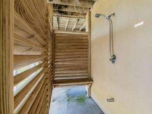 Una ducha a ras de suelo en una habitación con paredes de madera. en Sunglow Bungalow, en Pensacola Beach 32 fotos más