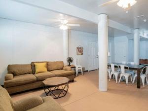 una sala de estar con un sofá, una mesa y sillas en Sunglow Bungalow, en Pensacola Beach