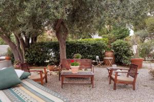 a patio with chairs and a table and a tree at Villa Marina Sant'Elia in Santa Flavia