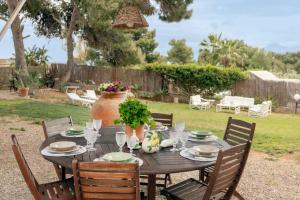 a wooden table with plates and glasses and a plant at Villa Marina Sant'Elia in Santa Flavia