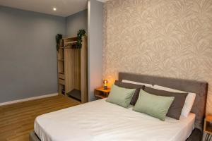 a bedroom with a bed with white sheets and green pillows at Capodichino airport house in Naples