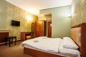 a hotel room with a bed and a television at KORSAR in Astana