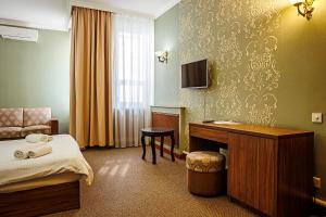 a hotel room with a bed and a desk at KORSAR in Astana