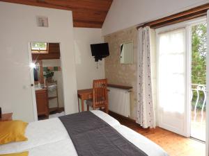 a bedroom with a bed and a window and a desk at Le Moulin De Saussaye in Crouzilles