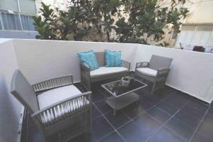 um pátio com 2 cadeiras e uma mesa em 4 Rooms steps from the beach em Tel Aviv