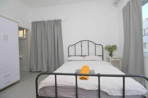 um quarto com uma cama com uma toalha laranja em 4 Rooms steps from the beach em Tel Aviv