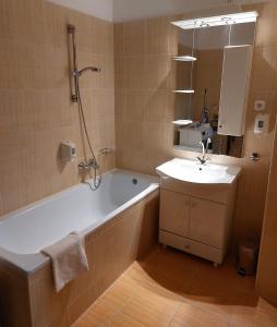 ein Badezimmer mit einer Badewanne und einem Waschbecken in der Unterkunft MyRelax Apartment in Hajdúszoboszló