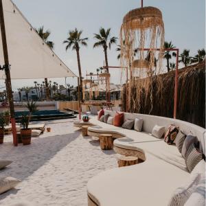 un patio con sofás blancos, mesas y palmeras en Wolf Suites, en Antalya