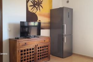 a television on a wooden cabinet next to a refrigerator at Apartment Cumbre Vieja Fuerteventura in Corralejo