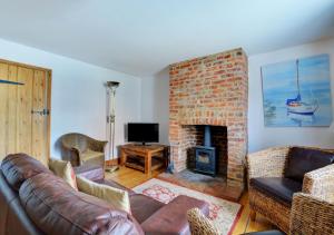 a living room with a couch and a fireplace at 18 The Green in East Rudham