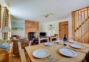 a dining room with a wooden table with wine glasses at 17 The Green in East Rudham