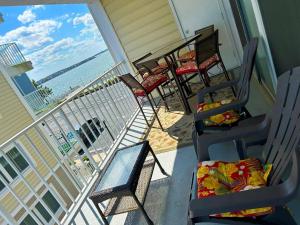a balcony with chairs and tables on a house at Thunder Island 75B condo in Ocean City