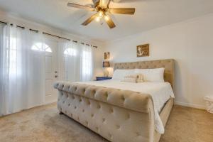 a bedroom with a large bed with a ceiling fan at Breezy Dauphin Island Vacation Rental with Deck! in Dauphin Island