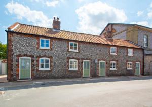 a large brick building with green doors on a street at 3 Port in Holt