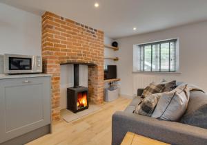 a living room with a brick fireplace and a couch at 3 Port in Holt
