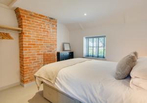 a bedroom with a brick wall and a bed at 3 Port in Holt