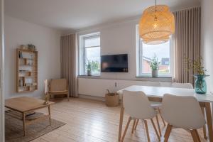 uma sala de estar com uma mesa e cadeiras e uma televisão em Newly renovated 1-Bed Apartment in Aalborg em Aalborg