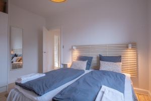 um quarto com uma cama grande com lençóis e almofadas azuis em Newly renovated 1-Bed Apartment in Aalborg em Aalborg