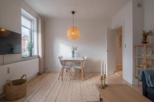 una sala de estar blanca con mesa y sillas en Newly renovated 1-Bed Apartment in Aalborg, en Aalborg