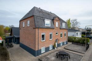 ein großes rotes Backsteingebäude mit schwarzem Dach in der Unterkunft Newly renovated 1-Bed Apartment in Aalborg in Aalborg