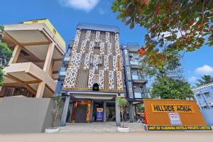 a tall building with a sign in front of it at Townhouse OAK Hillside Aqua in Khandagiri