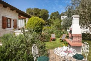 een tuin met een tafel en stoelen en een open haard bij Apartment Antonia in Novigrad Istria