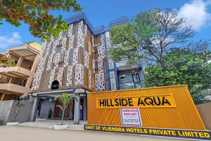 a building with a yellow sign in front of it at Townhouse OAK Hillside Aqua in Khandagiri