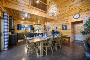 a kitchen and dining room with a table and chairs at Hickory Bear - Cabin surrounded by pines, Sleeps 10, Hot Tub, Fire Pit, Arcade, Foosball Table & Deck Slide in Broken Bow