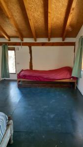 a room with a bed with a red sheet at Cabaña km 12,7 in San Carlos de Bariloche