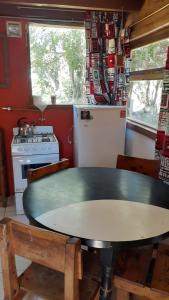 a kitchen with a table and a refrigerator at Cabaña km 12,7 in San Carlos de Bariloche