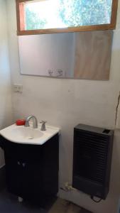 a bathroom with a sink and a mirror at Cabaña km 12,7 in San Carlos de Bariloche