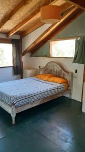 a large bed in a room with two windows at Cabaña km 12,7 in San Carlos de Bariloche
