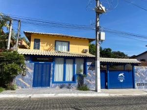 a blue and yellow house on a street at Pousada Maresias de Geribá in Búzios