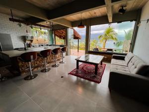 uma sala de estar com um sofá e um bar em Linda casa em condomínio fechado com vista para Ilha das Cabras em Ilhabela