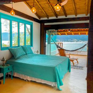 um quarto com uma cama e vista para o oceano em Linda casa em condomínio fechado com vista para Ilha das Cabras em Ilhabela