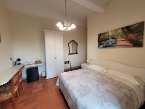 1 dormitorio con cama, mesa y espejo en Casa Volpini, en Panzano
